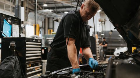 Man Working Under Bonnet of Car